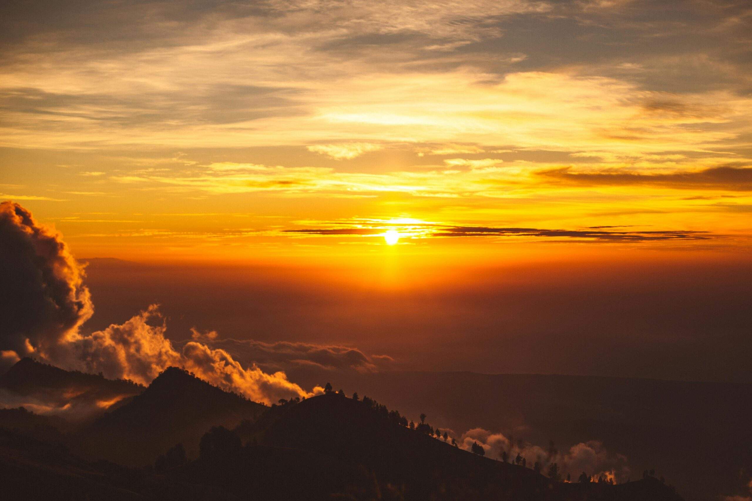 A breathtaking photo of snowshoers overlooking a mountain ridge during sunset.