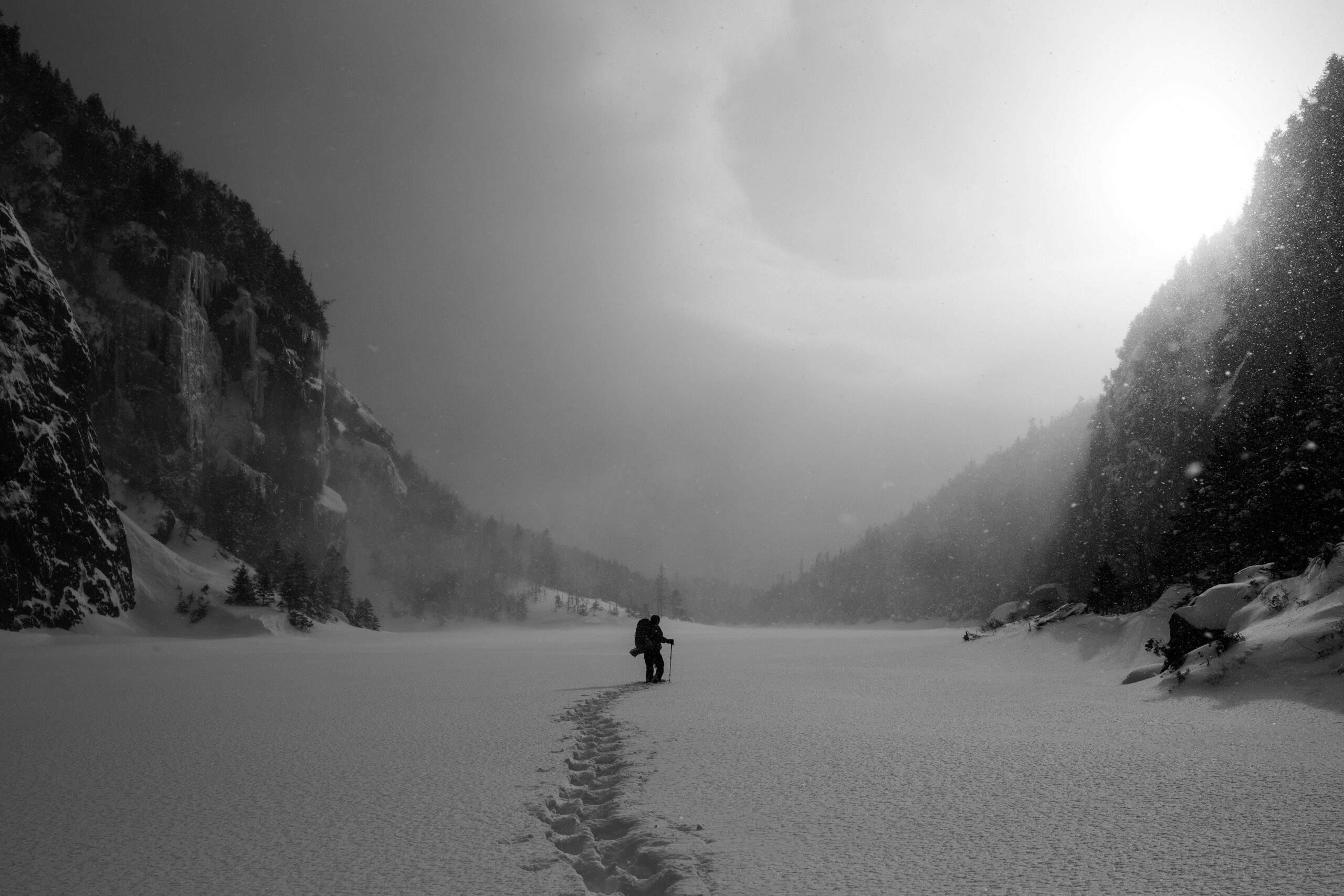 A lone hiker struggling against icy winds and deep snow
