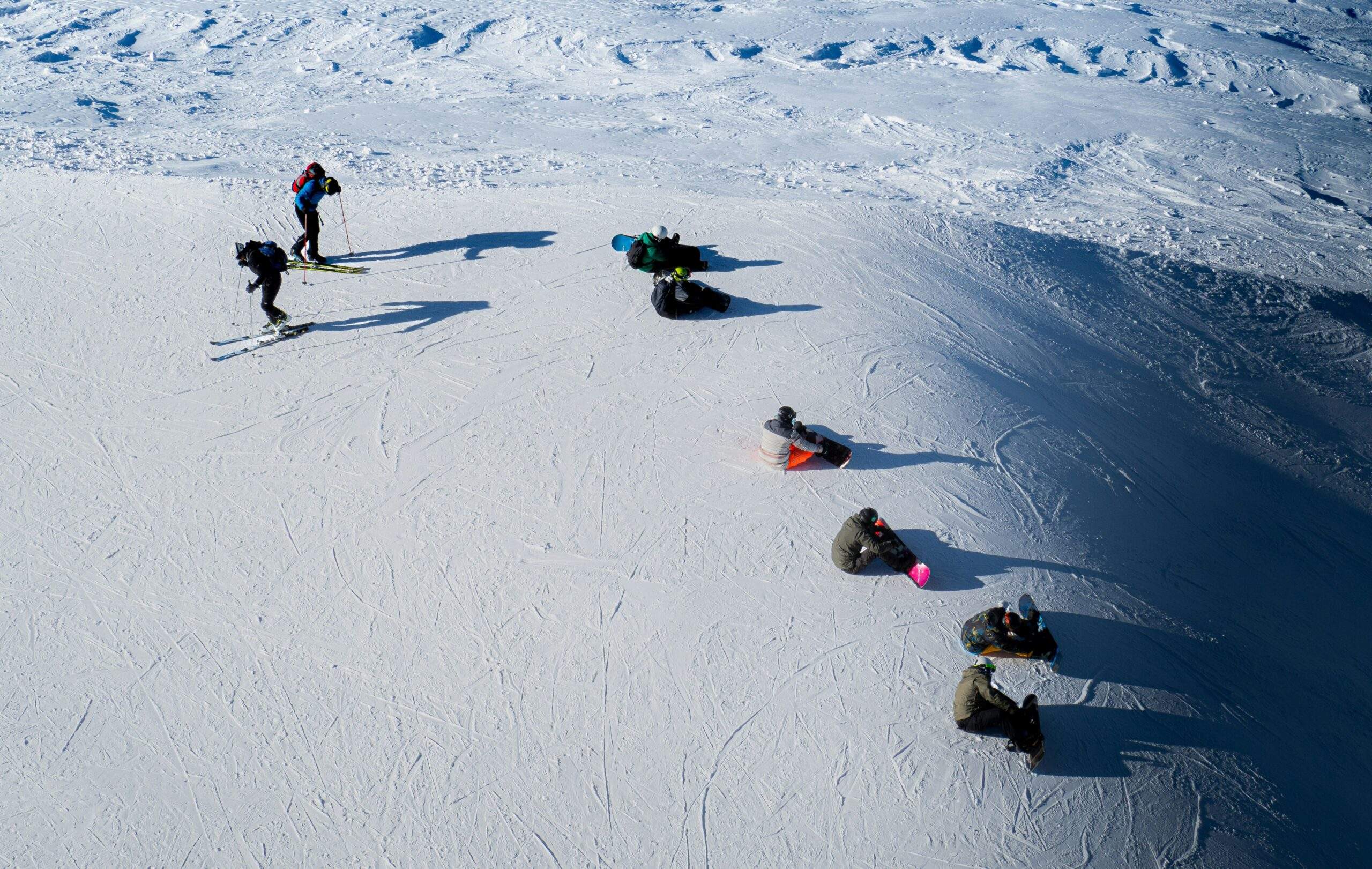 Group of tourists arriving at a snowy trailhead via rented snowmobiles