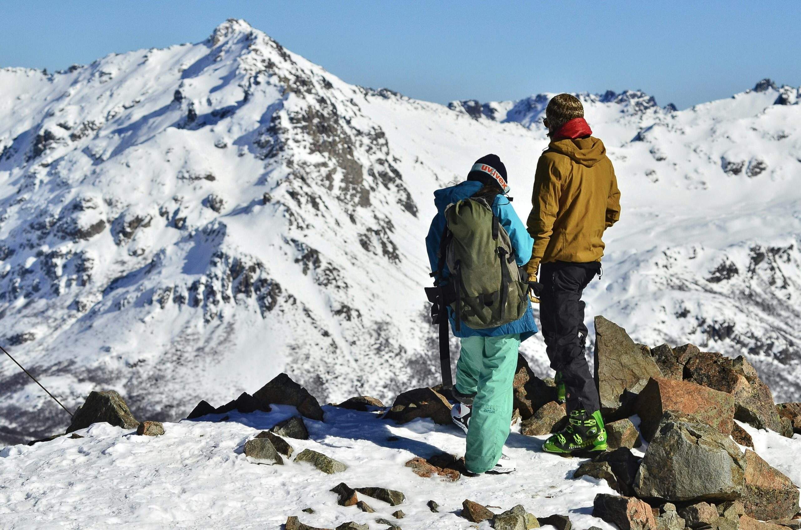 Two hikers celebrating reaching a snowy summit together