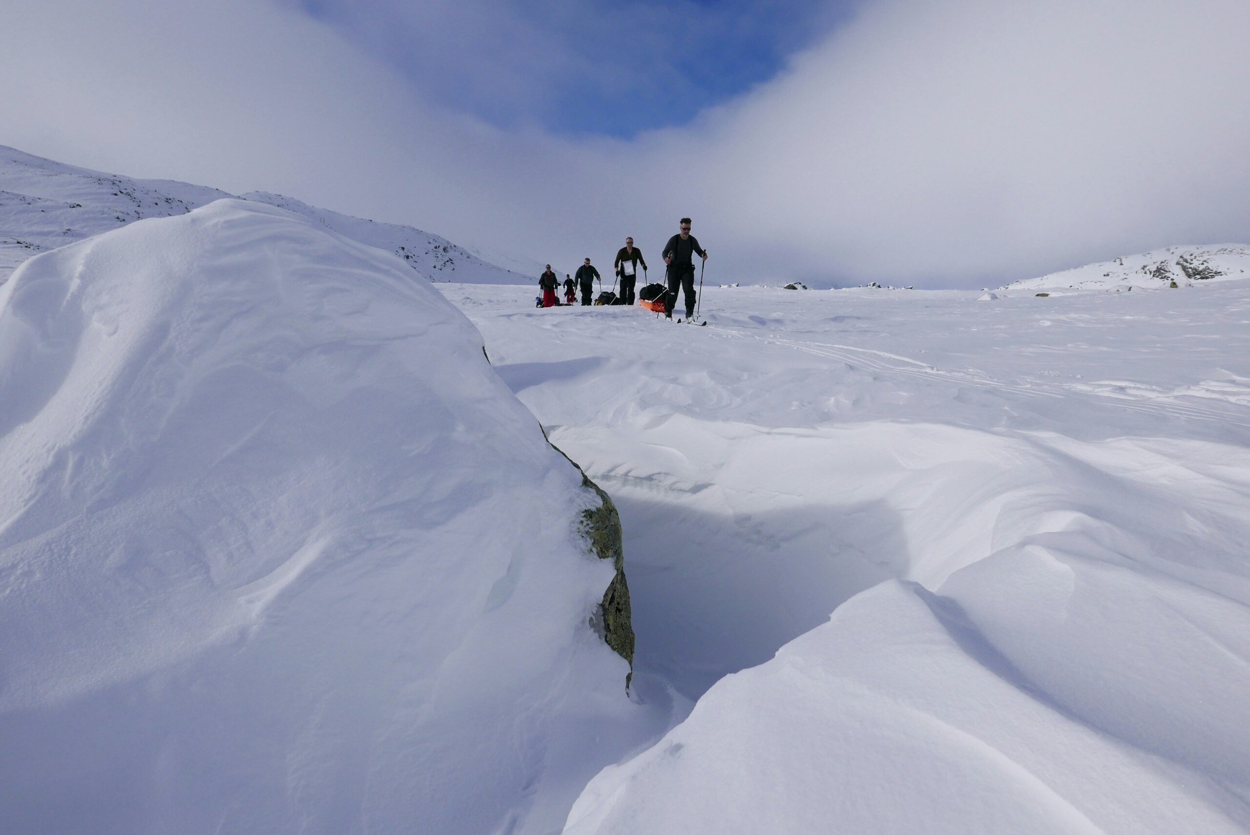 An experienced guide explaining how to properly wear snowshoes during a group tour.