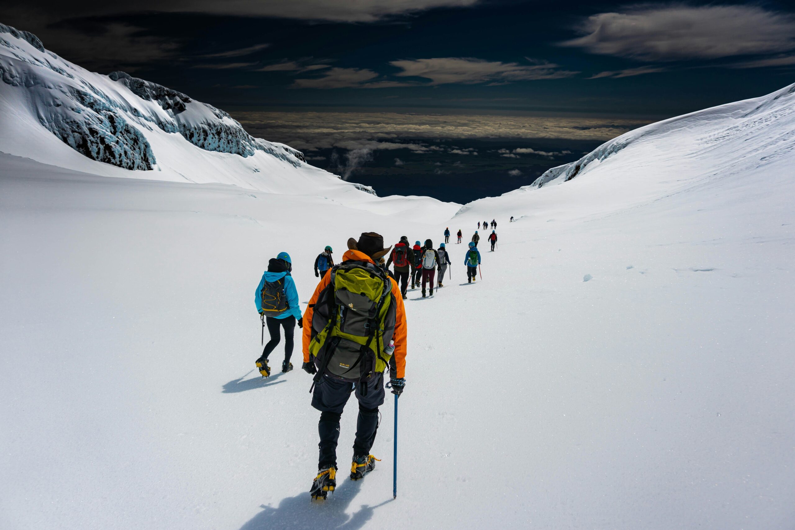 An experienced guide helping tourists adjust their snowshoes before a trek