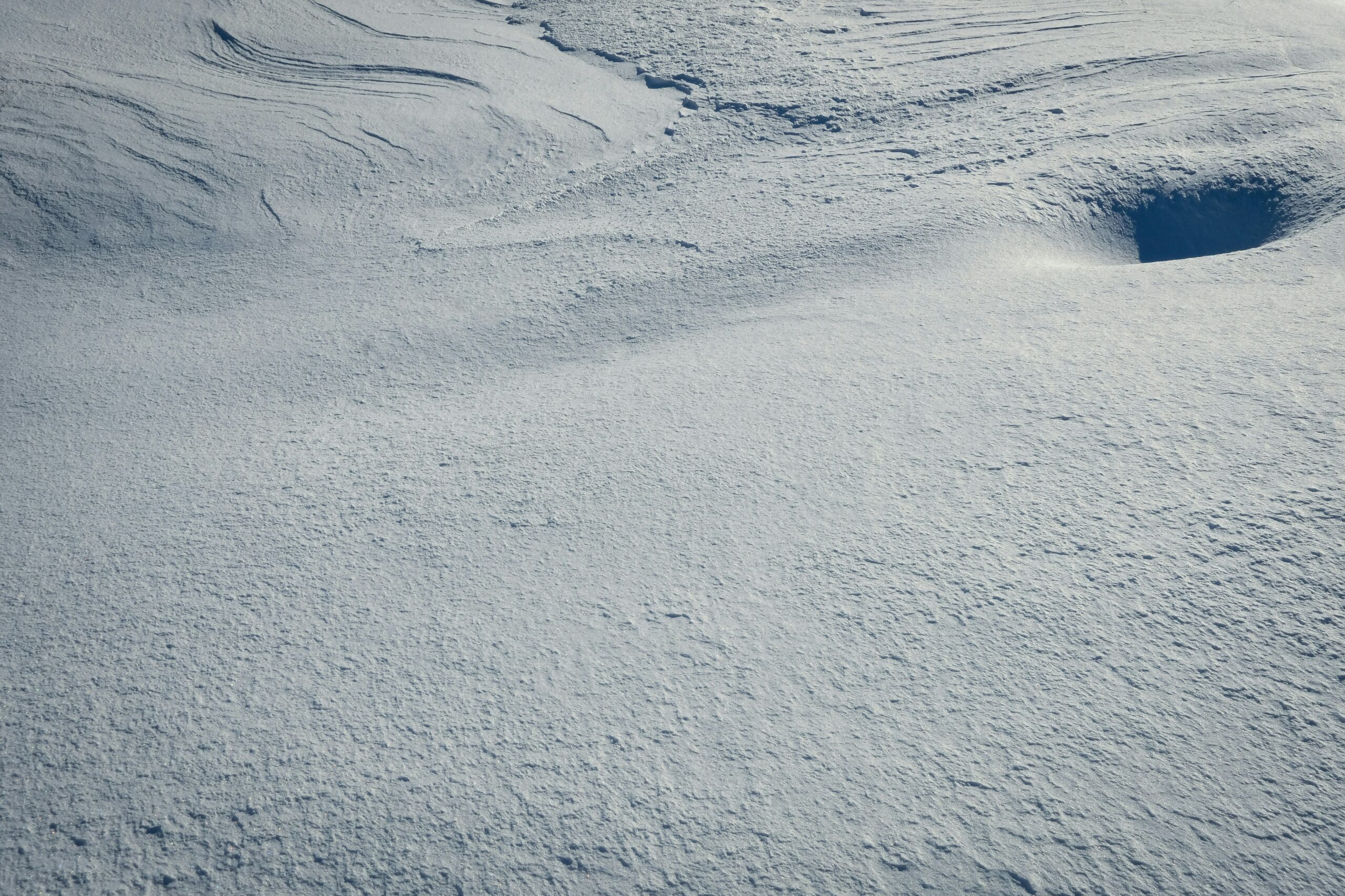 Golden hour sunset casting a warm glow over snowy mountains