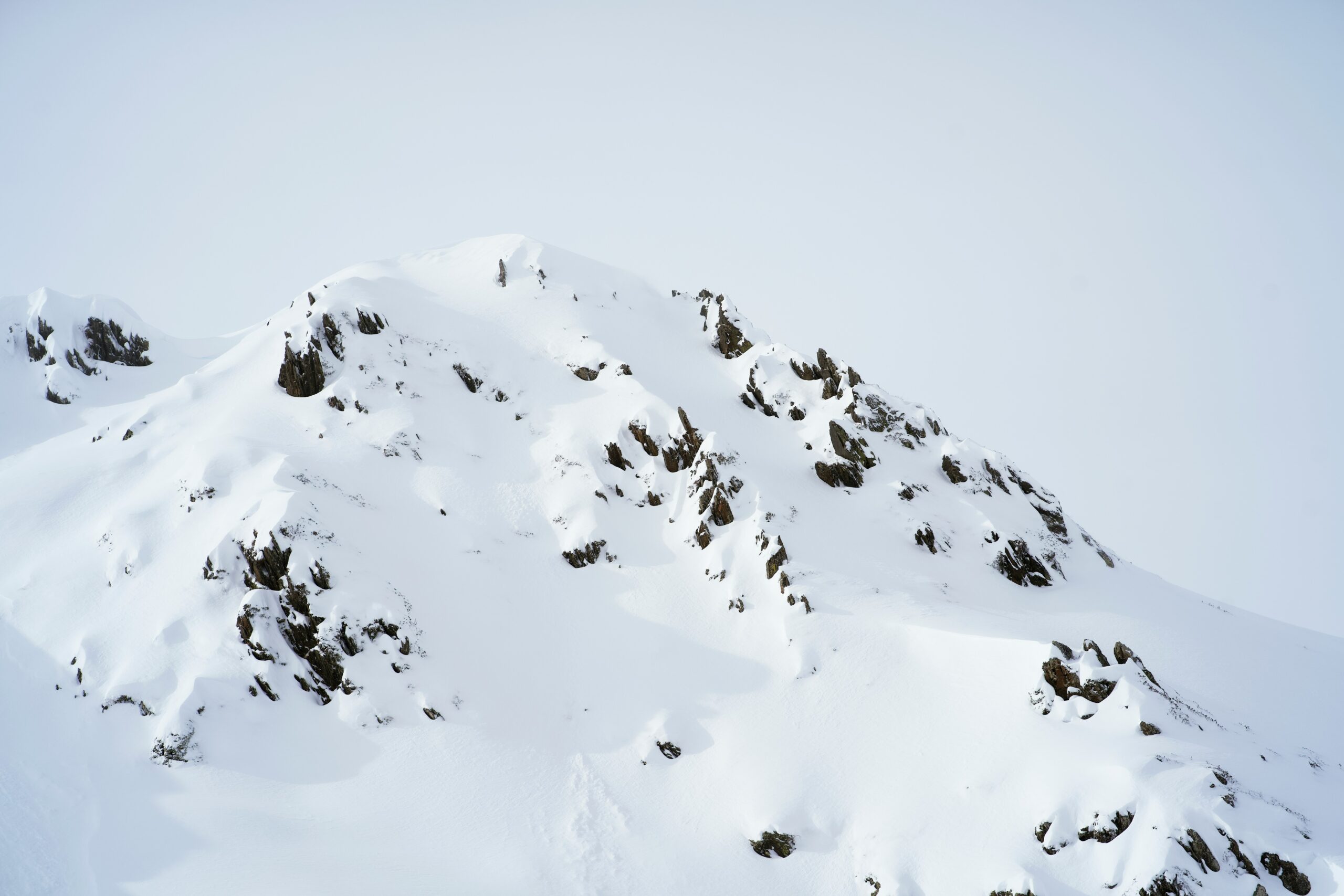 a snowboarder is going down a snowy mountain